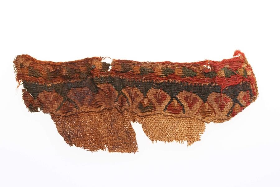 Roman Egypt Coptic Linen Textile Fragment, Circa 4th-5th Century AD.  A rectangular piece with leaves and fruits, is intact as a piece, has a brown, light brown and red colors, it measures 45 x 115 mm.