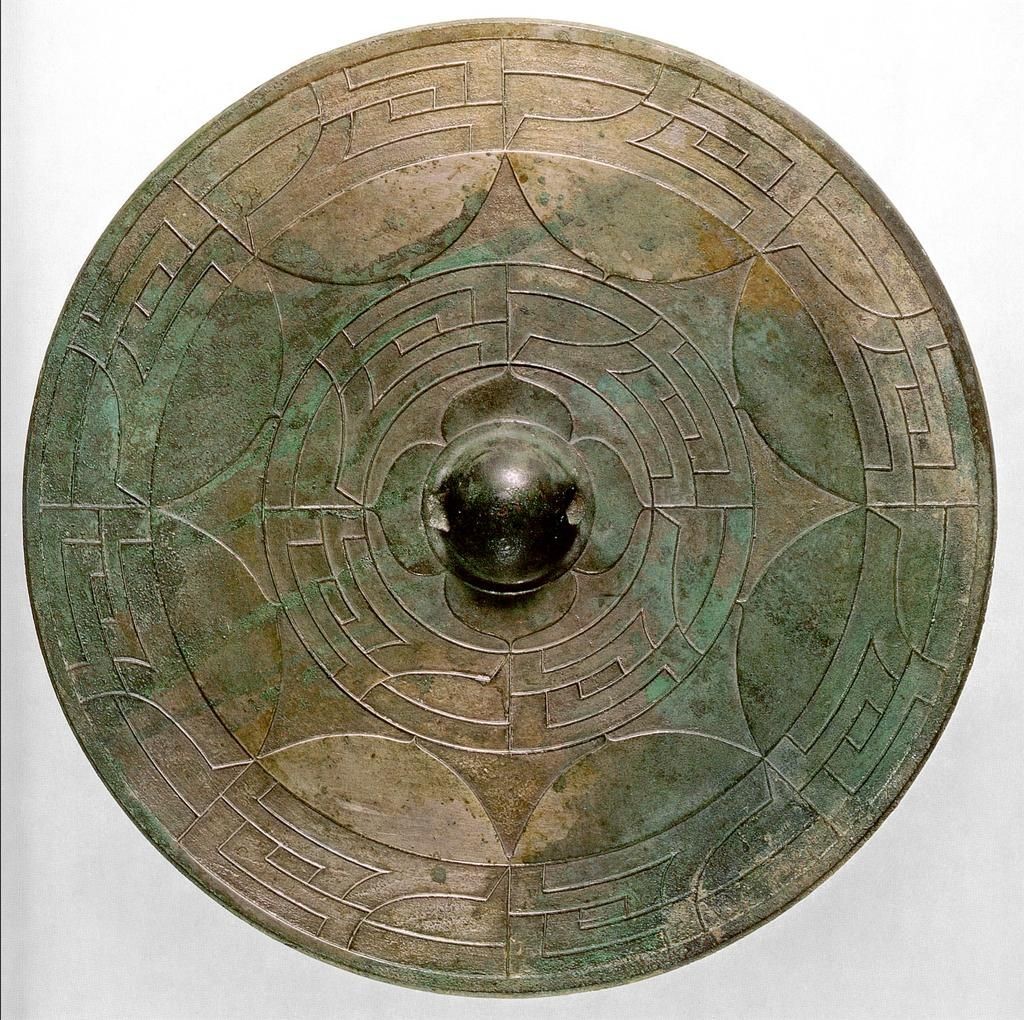 Mirror back, 4th century. Bronze, diam. cm. 28. Tokyo, Imperial Collection. Known as chokkomon ("straight and curved lines"), the geometric decoration that characterizes the back of this bronze mirror already heralds one of the most typical characteristics of all Japanese art, or the movement of the line as the basis for the construction of the ornamented.